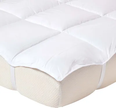 A close-up view of a white mattress topper on a mattress.