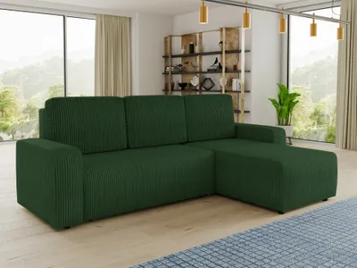 A green sectional sofa is shown in a modern living room with large windows and a bookshelf in the background.