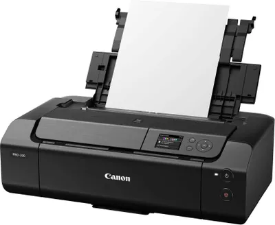 A black Canon PIXMA PRO-200 photo printer with a sheet of paper in the paper feeder.