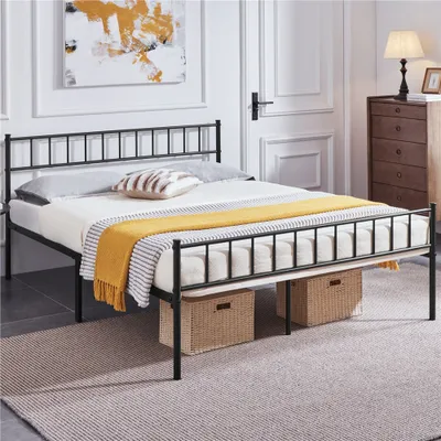 A bedroom scene featuring a black metal bed frame with a mattress, pillows, and a yellow blanket.
