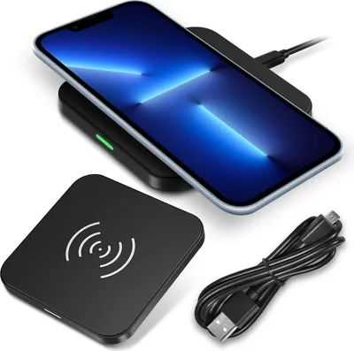 A smartphone is charging wirelessly on a charging pad, with another charging pad and a USB cable visible in the foreground.