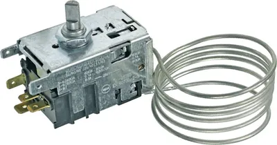 A close-up shot of a refrigerator thermostat with a coiled capillary tube.