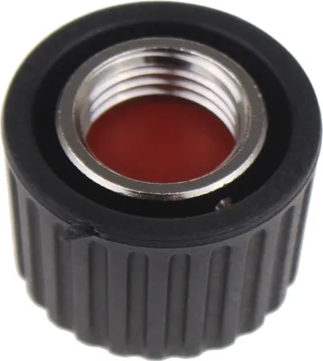 Close-up of a black threaded cap with a silver metal insert and a red interior.