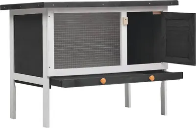 A wooden rabbit hutch with two drawers and a wire mesh front.