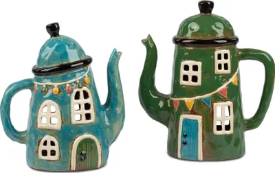 Two decorative teapots shaped like houses, displayed side-by-side against a white background.