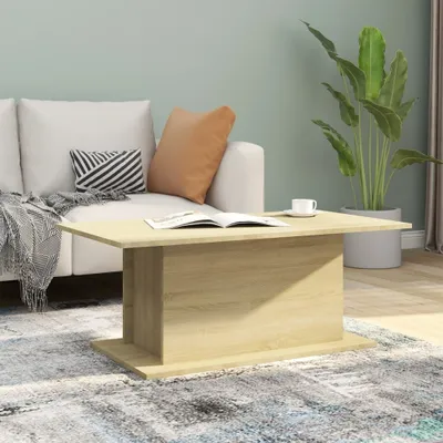 A living room scene with a couch, coffee table, and plant.
