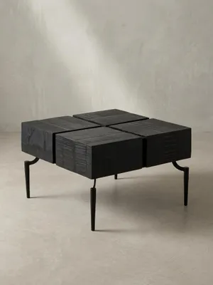 Schräge 3/4-Ansicht des schwarzen Cube-Couchtischs, die die Tiefe der viergeteilten Tischplatte und die filigranen Metallbeine zeigt._#sku_SAFWL6.980#