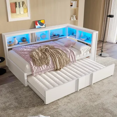 A white corner daybed with a pull-out trundle bed, featuring built-in shelving illuminated by blue LED lights.