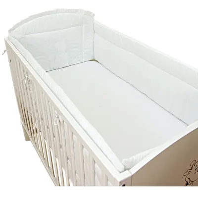 A white baby crib with a white mattress and bumper pad.