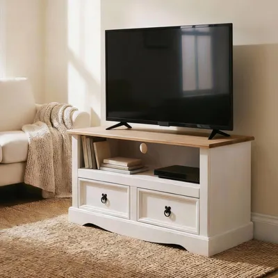 A TV stand with a TV on top, placed in a living room setting next to a sofa.