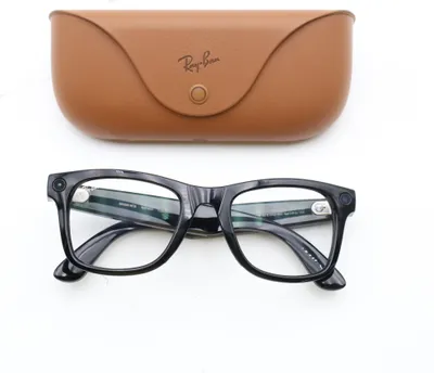 A pair of black Ray-Ban Wayfarer glasses and their brown leather case are displayed on a white background.