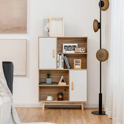 A white and wood-colored bookshelf with various decorative items on its shelves.