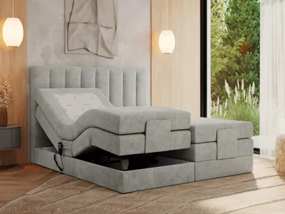 A modern adjustable bed with a headboard and storage base, shown in a bedroom setting with natural light from a window.