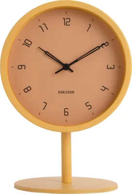 A yellow Karlsson table clock with an orange face is shown against a white background.