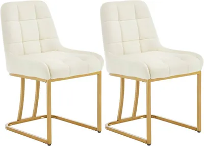 Two beige upholstered dining chairs with gold metal frames are shown against a white background.
