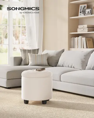 A living room scene with a sofa, pillows, and an ottoman.