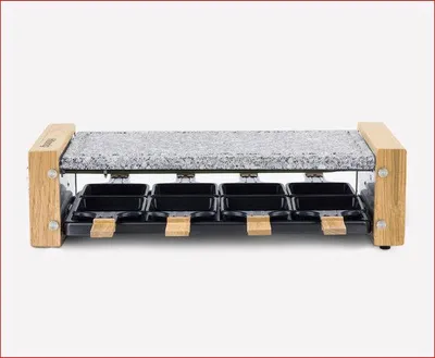 A raclette grill with a granite stone top and eight individual cooking pans.