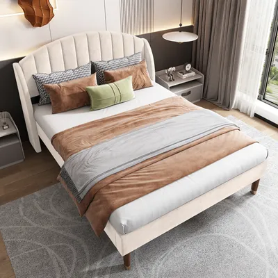 A bedroom scene featuring a beige upholstered bed with pillows and blankets.
