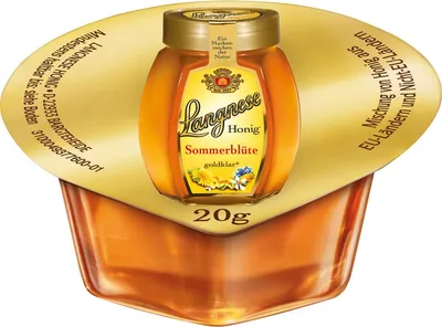 A small jar of Langnese honey with a gold lid, presented in a gold-colored blister pack.