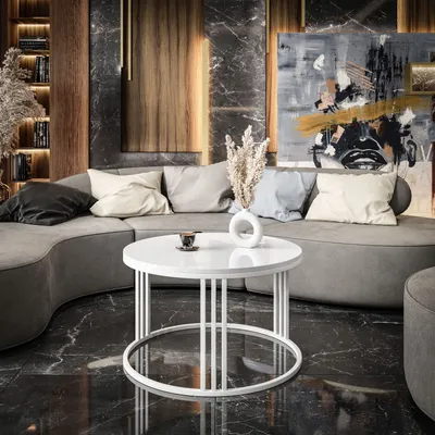 A modern living room with a curved sofa, abstract art, and a round coffee table.