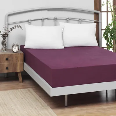 A bed with a purple fitted sheet and white pillows.