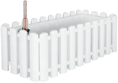 A white rectangular planter with a picket fence design around the sides. A thermometer is inserted into the planter.