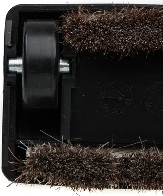 A close-up view of the underside of a vacuum cleaner attachment, showing a wheel and bristles.