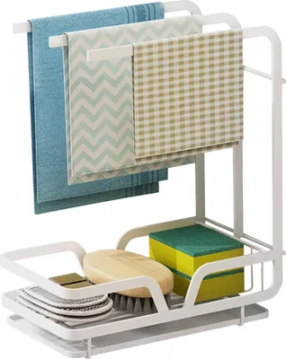 A white kitchen organizer rack holding dish towels, sponges, and a brush.