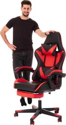 A man stands next to a gaming chair.