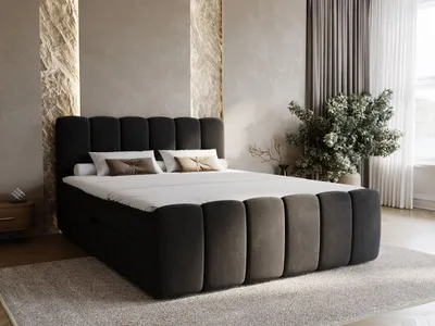 A modern bedroom scene featuring a large, upholstered boxspring bed.