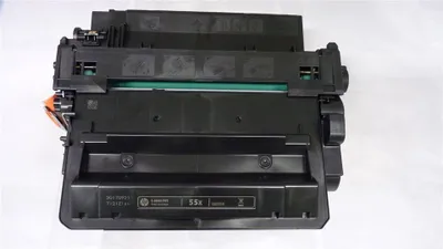 A black toner cartridge is shown against a white background.