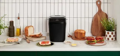 A kitchen counter with a bread maker and various bread products.