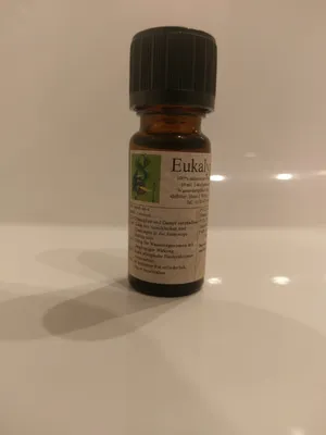 Kleine braune Flasche mit einem schwarzen Verschluss. Auf dem Etikett steht "Eukalyptus".