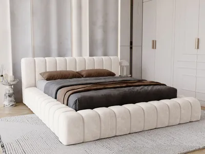 A modern bedroom with a cream upholstered bed.