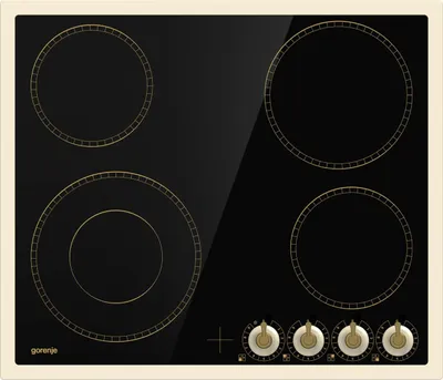 A top-down view of a black glass ceramic hob with gold detailing and cream trim.