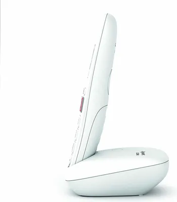 A white cordless phone handset is docked in its charging base, shown from the side against a white background.