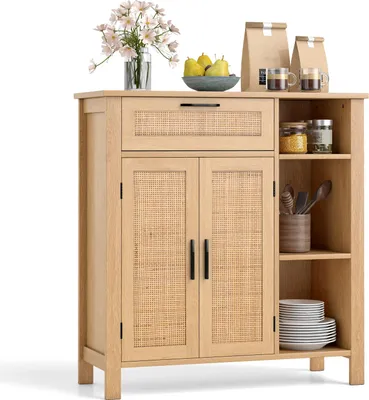 A wooden sideboard with rattan doors, a drawer, and open shelves, decorated with flowers, fruit, and jars.