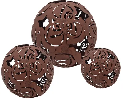 Three decorative spheres with a cut-out floral pattern, appearing to be made of rusted metal.