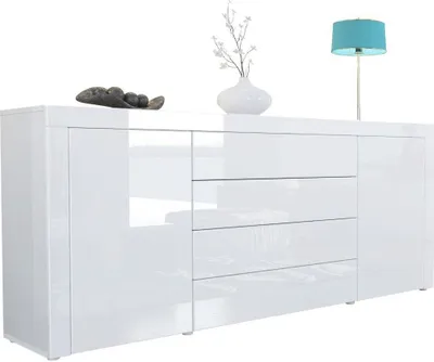 A white high-gloss sideboard with drawers and doors, decorated with a vase of branches and a decorative stone.