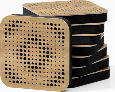 A stack of square acoustic panels with a wooden top layer featuring a pattern of holes and a black foam layer underneath, presented against a white background.