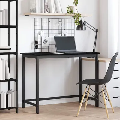 A minimalist desk setup with a laptop, lamp, and chair.