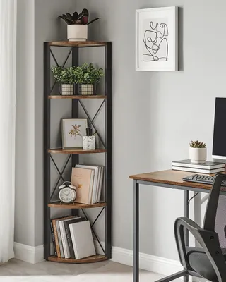 A corner shelf unit with books and plants next to a desk.