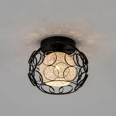 A black metal cage ceiling light with a white woven sphere.
