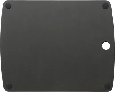The underside of a black cutting board with four black rubber feet and a circular cutout on the right side.