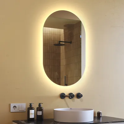 A bathroom sink with a mirror above it, illuminated by LED lights.