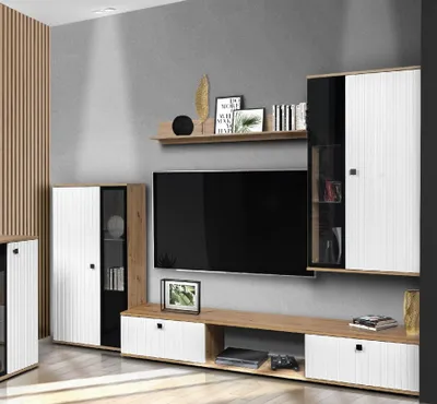 A modern living room setup featuring a wall unit with a TV, shelves, and cabinets.