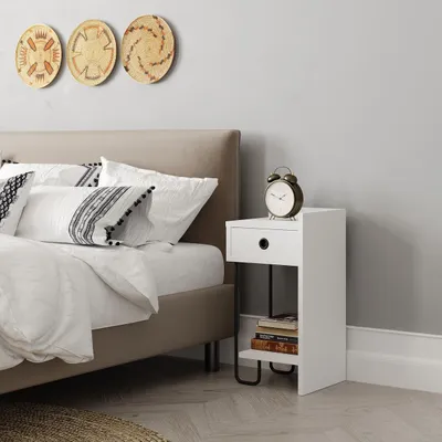 A bedroom scene with a bed, nightstand, and wall decor.