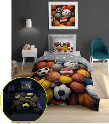 A bedroom scene with a bed featuring a comforter and pillow with a sports ball theme. A small inset image shows the bedding in a darker setting, highlighting a glow-in-the-dark feature.