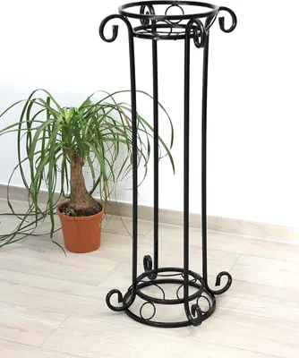 A black metal plant stand with a potted plant next to it.