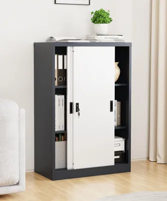 A dark gray metal filing cabinet with white sliding doors, filled with books and folders, placed in a room.